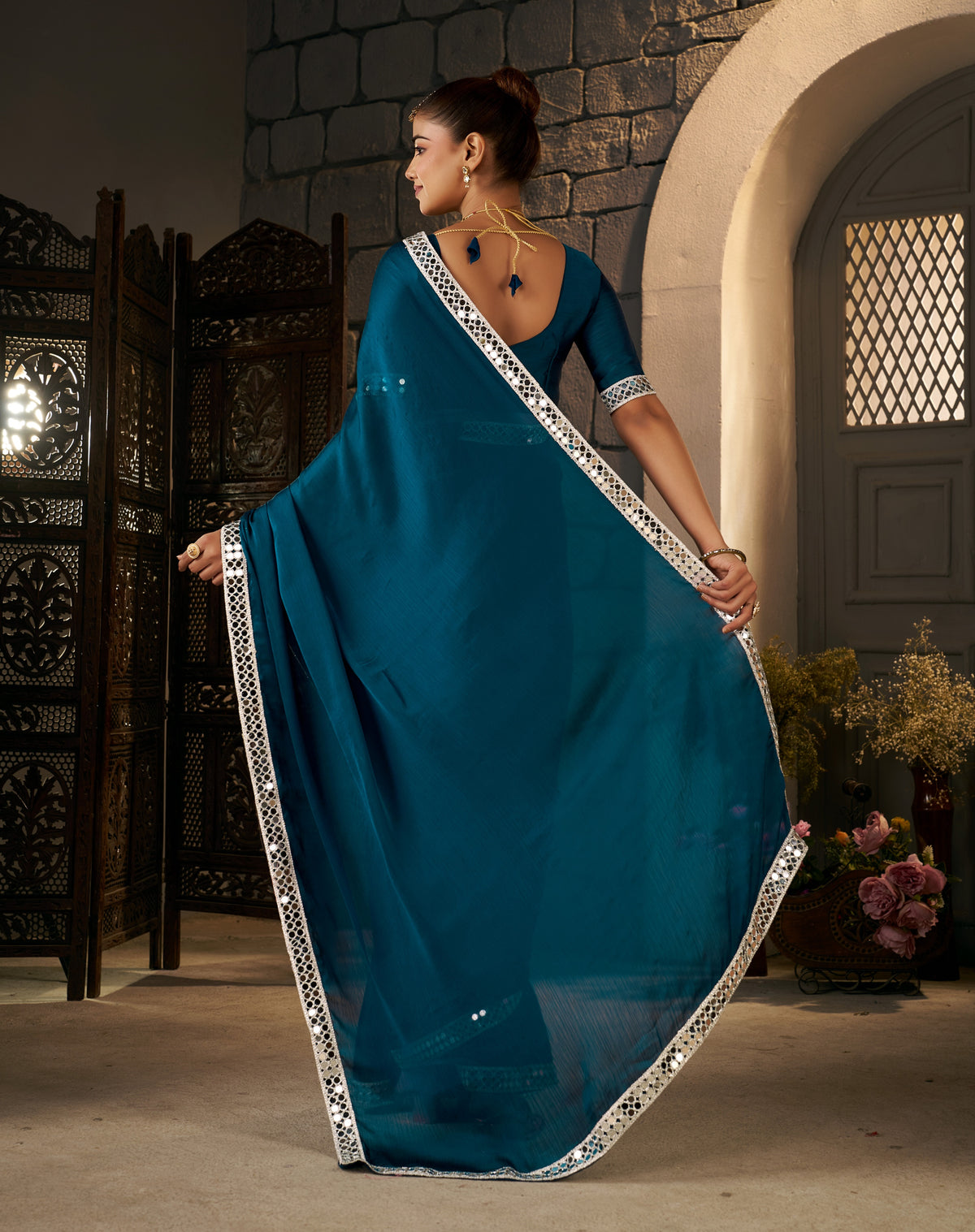 pallu detail of peacock blue ethnic saree with silver mirror work