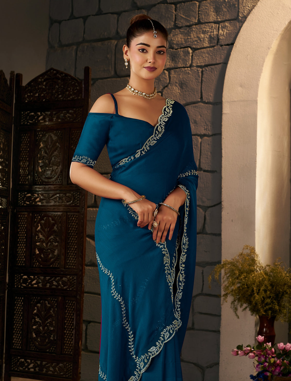 close-up of the gold stonework border on the peacock blue designer saree.