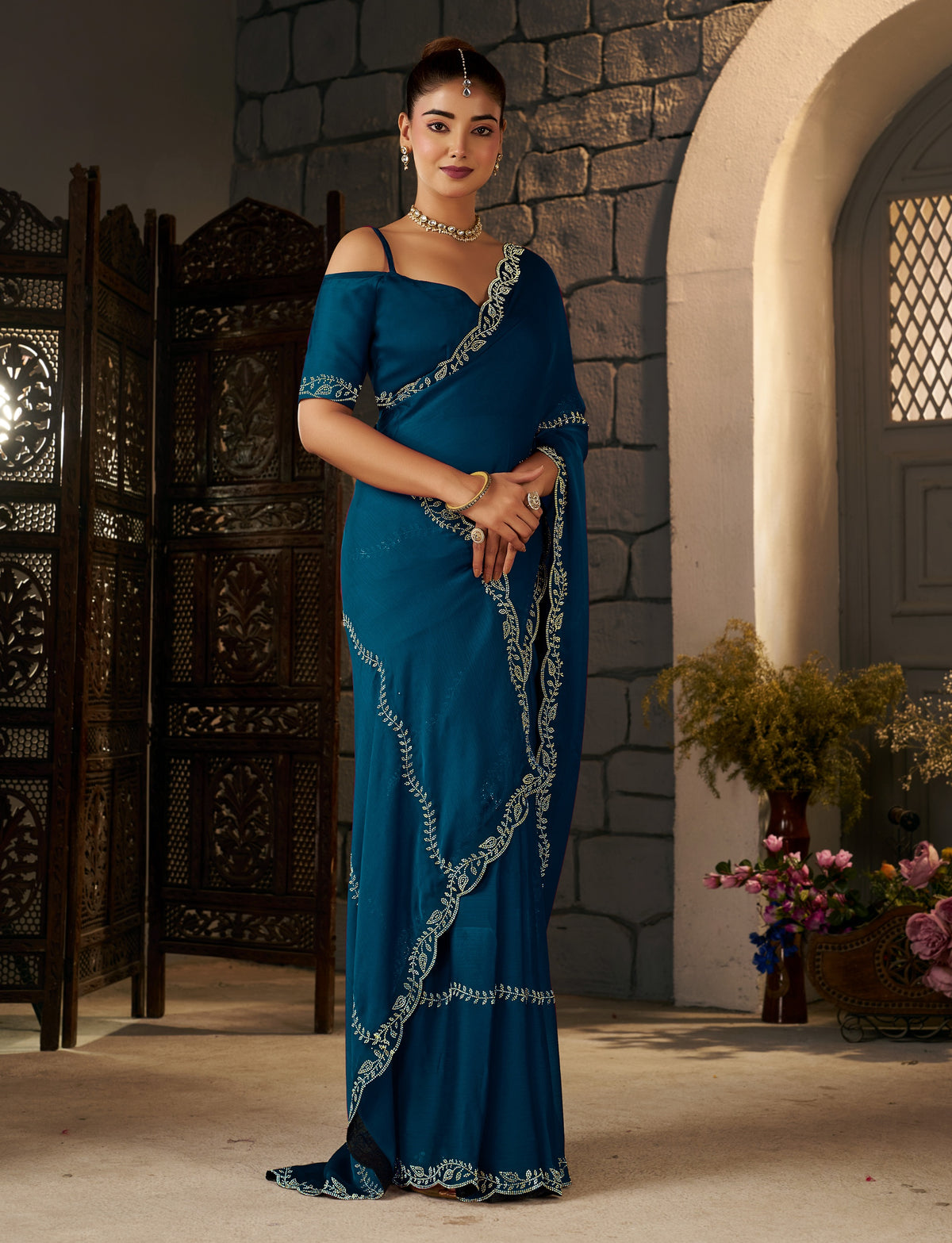 side profile of the peacock blue gold stonework designer saree with gold stonework border.