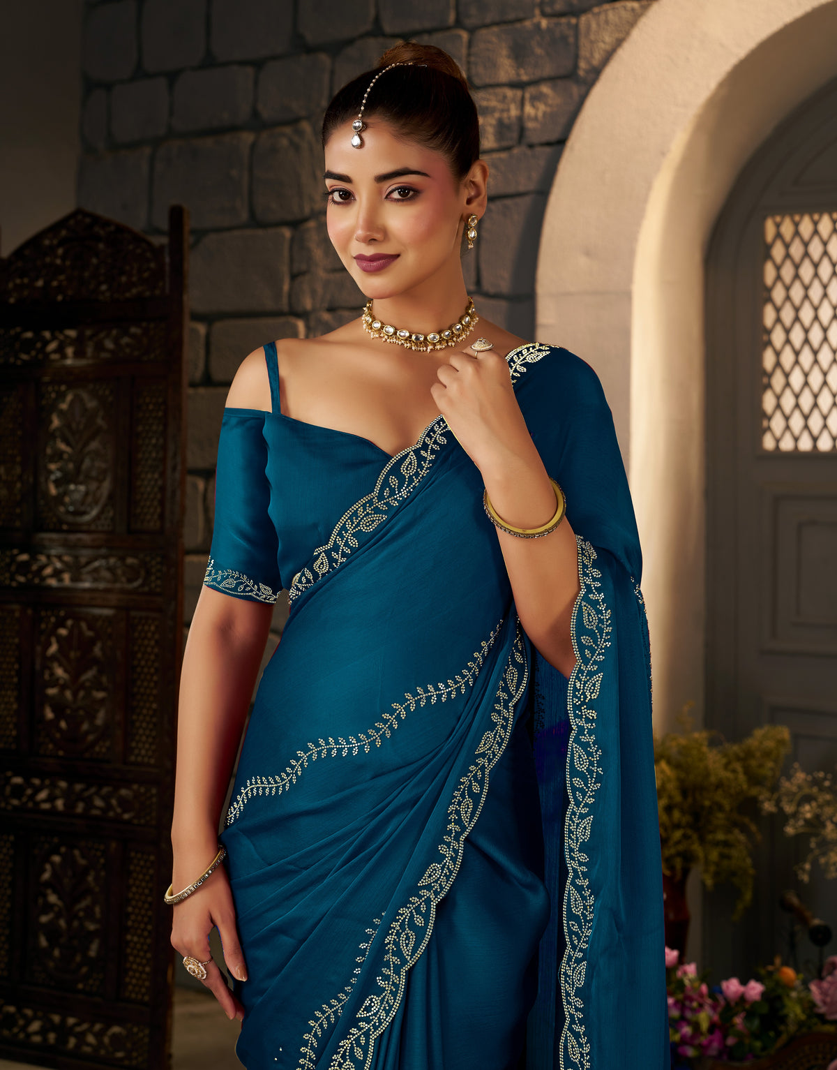 Intricate gold stonework embellishments on the Peacock Blue Designer Saree.
