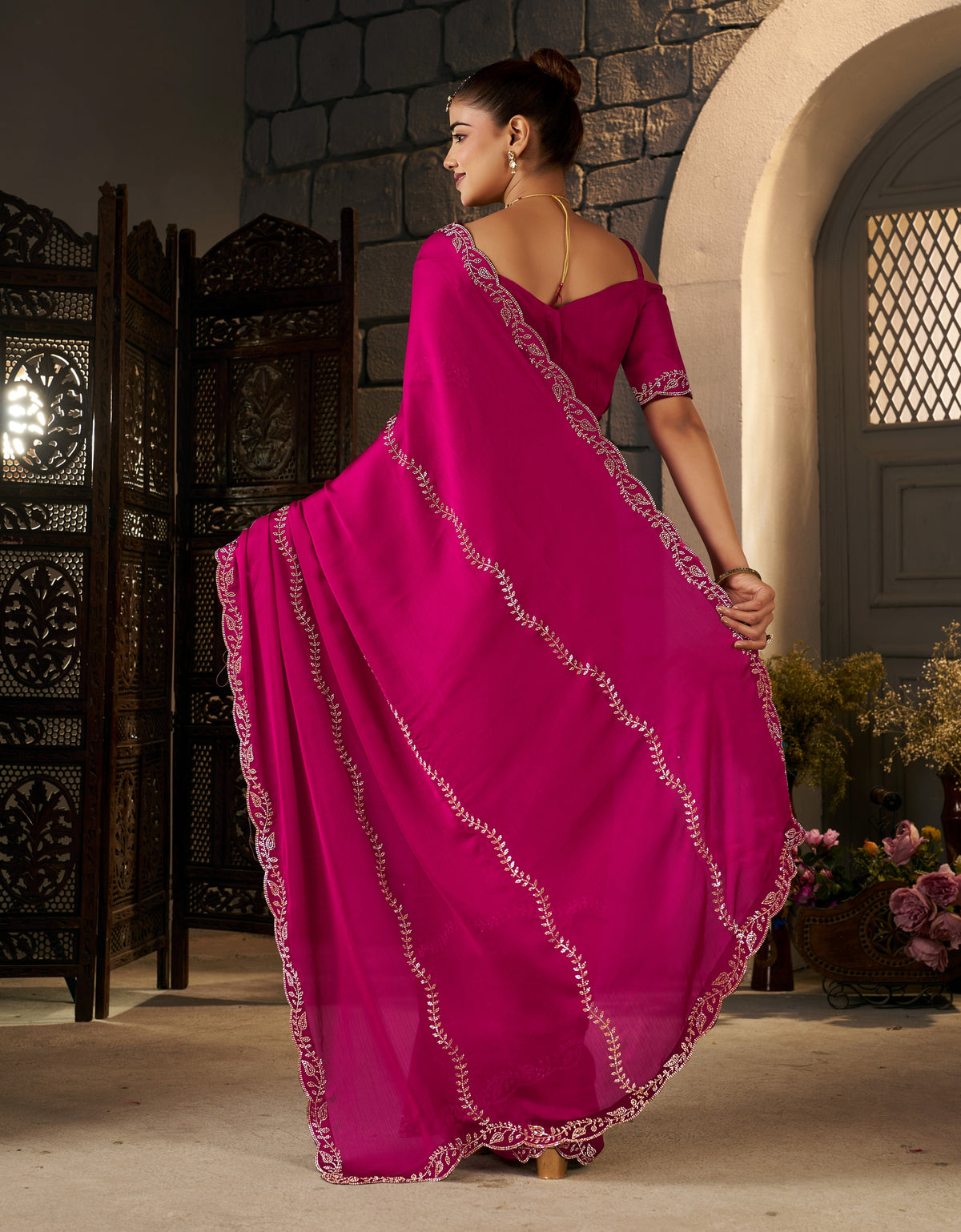 detailed view of the pallu with intricate gold stonework on the pink designer saree.