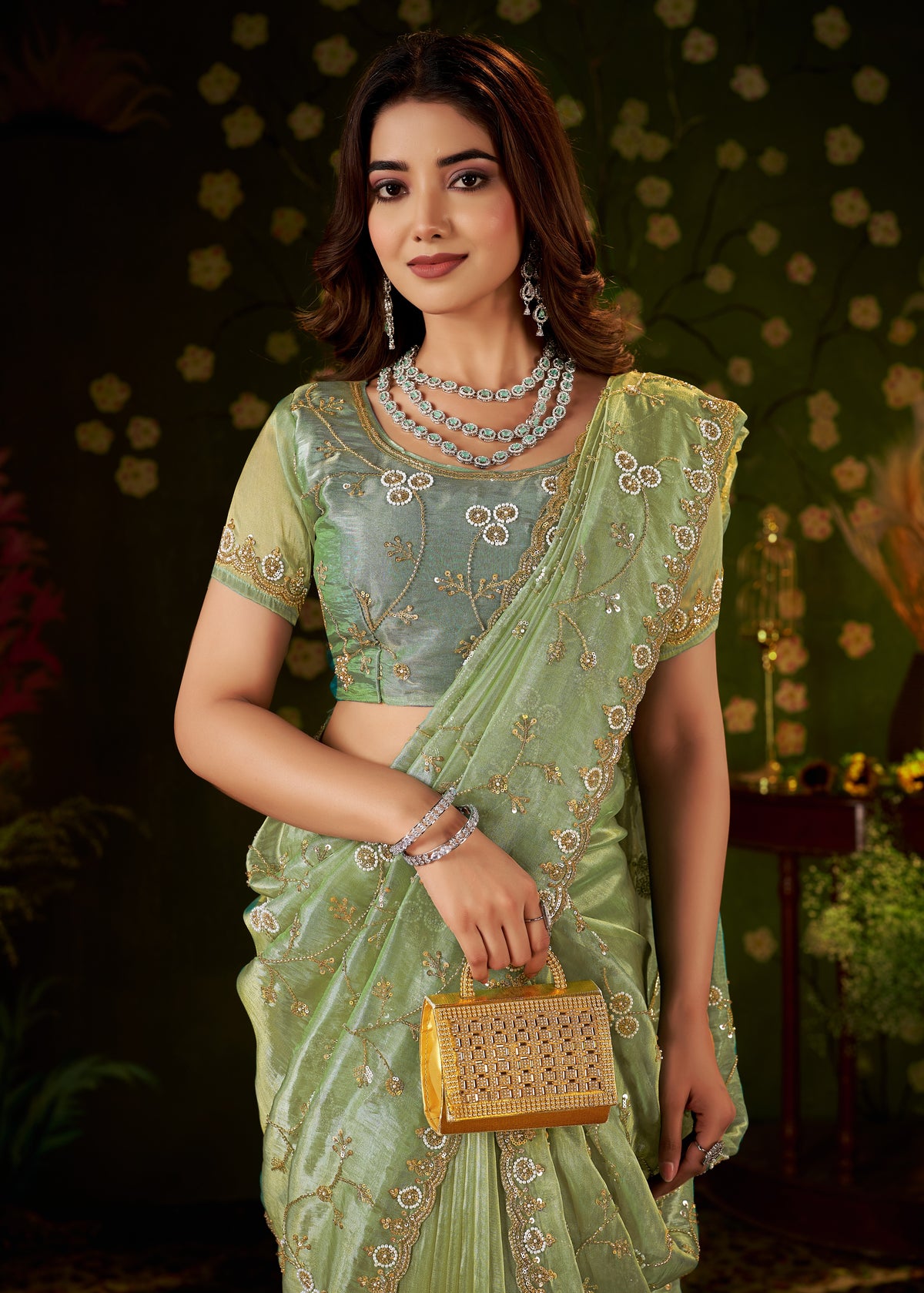 woman wearing chhoga pistachio green floral vine tissue silk saree with elegant hand work - half view