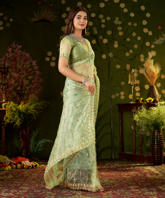 Detailed side view of pistachio green saree showing scalloped waist border and floral embroidery.